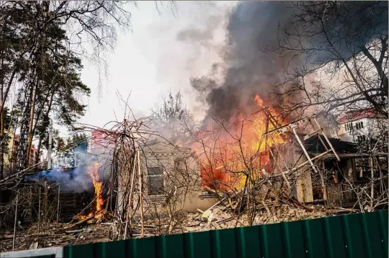  ?? Marcus Yam / Tribune News Service ?? Flames consume a home in Irpin, one of many Ukrainian cities under Russian bombardmen­t on Saturday. Cease-fire talks failed again.