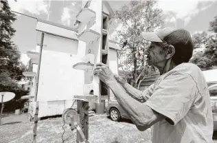  ?? Photos by Kim Brent / The Enterprise ?? Howard Orphey checks on the babies in one of the large Martin birdhouses which he has built and maintains at his home in Beaumont’s South Park neighborho­od.