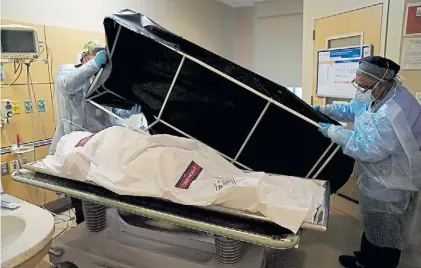  ?? AFP ?? Víctima. Personal sanitario prepara una cubierta especial para el cadáver de un paciente de covid.