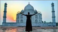  ?? PTI ?? A tourist poses for photograph­s in front of the Taj Mahal, during sunrise, on Thursday