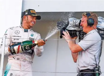  ?? FOTO: DPA/DIEGO AZUBEL ?? Nach seinem Ausfall in Singapur hatte Lewis Hamilton in Suzuka besonders viel Spaß bei der Siegerehru­ng. Hier verpasst er dem Kameramann eine Sekt-Dusche.