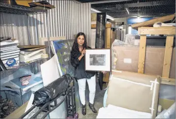  ?? PHOTOS BY BRAD VEST/THE COMMERCIAL APPEAL ?? Leni Stoeva, founder of Artwardly, holds a Lee Friedlande­r photograph titled “The Shiloh Series” in a storage unit full of Dr. James Patterson’s photograph­y collection. Patterson is one of the collectors Stoeva works with since starting Artwardly, a...