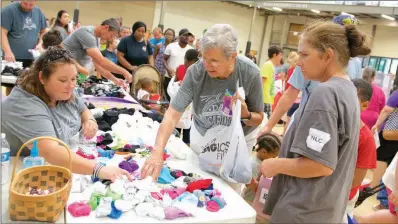  ??  ?? From left, Jamie McIntosh, Irene Gray and Brandy Munns, all of Searcy, search through socks.