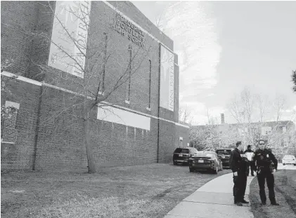  ?? ULYSSES MUÑOZ/BALTIMORE SUN ?? Police stand outside Frederick Douglass High School last Friday. Students were dismissed early that day after a 56-year-old staffer was shot inside the building. Officials say a 25-year-old man entered the school shortly after noon and shot a special education assistant.