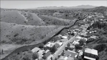  ?? ASSOCIATED PRESS ?? THIS APRIL 2, 2017, FILE PHOTO MADE WITH A DRONE shows the U.S./Mexico border fence as it cuts through the two downtowns of Nogales, Ariz. The Arizona Attorney General’s Office is seeking more funding to ease the burden brought by a rise in cases at the border.