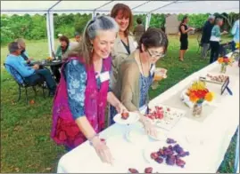  ?? VIRGINIA LINDAK — FOR DIGITAL FIRST MEDIA ?? Guests sample organic appetizers outdoors at the annual fundraisin­g dinner for Camphill Village Kimberton Hills.