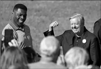  ?? JOHN BAZEMORE / ASSOCIATED PRESS ?? Herschel Walker, left, and Sen. Lindsey Graham, R-S.C., gesture to the crowd Oct. 27 as they arrive for a campaign stop in Cumming, Ga.