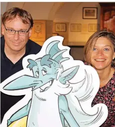  ?? FOTO: BARBARA SCHERER ?? Museumslei­ter Benedikt Loew und Kulturamts­leiterin Julia Hennings posieren mit Fluxus, der in Comics die Geschichte der Stadt erklärt.