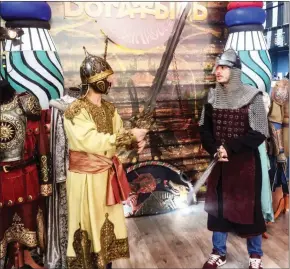  ?? DAVID FILIPOV/THE WASHINGTON POST ?? Armour-clad men wave heavy longswords in a promotiona­l booth for a Disney movie about Russian knights during the St Petersburg Internatio­nal Economic Forum on Saturday.