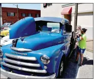  ?? (NWA Democrat-Gazette/Mark Humphrey) ?? Lacie Bell, 3, of Greenland, gets a lift from her mother, Abbie Bell, on June 25 to peek inside a 1948 Dodge pickup owned by W. Soucie during the 11th annual Chicken Rod Nationals at the Lincoln Square.