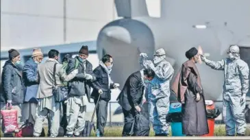  ??  ?? Indian nationals being screened at the airbase after they were evacuated from coronaviru­s-hit Iran at Hindon airport on Tuesday.
PTI