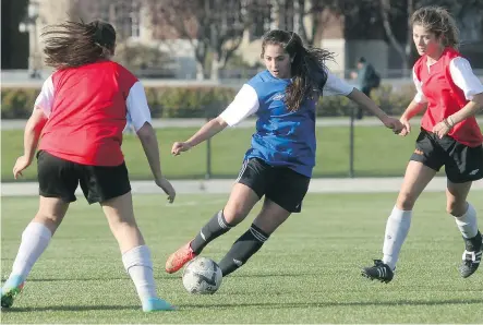  ?? TED RHODES/ CALGARY HERALD ?? Striker Taya Tahir of Ernest Manning High School, playing for the South Team, splits a pair of North Team opponents during the Calgary High School Selects Soccer action on Friday at SAIT.