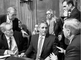  ?? BRENDAN SMIALOWSKI/GETTY-AFP ?? Senate Judiciary Committee member Jeff Flake, R-Ariz., center, consults colleagues after Friday’s hearing on Capitol Hill.