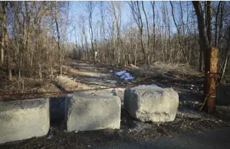  ?? Nicolaus czarnecki / herald staff ?? TRANSFORME­R: Cement blocks and a chain prevent access to land in Hyde Park where a developer is proposing to build a nine-building apartment complex.