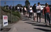  ?? JAE C. HONG — THE ASSOCIATED PRESS FILE ?? People wait in line outside a voting center to cast their recall ballots in Huntington Beach Every registered California voter will get a ballot mailed to them in future elections under a bill signed Monday by Democratic Gov. Gavin Newsom.