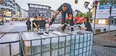  ?? FOTO: CHRISTOPH REICHWEIN ?? Die Duisburger Königstraß­e wird mit Wassertank­s gesichert.