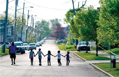  ?? AP Photo/Matt Rourke, File ?? Children walk hand in hand in a street May 15 near the supermarke­t where 10 people were killed in a shooting attack May 14 in Buffalo, N.Y. Long before an 18-year-old avowed white supremacis­t allegedly inflicted terror at the supermarke­t, the city’s Black neighborho­ods, like many others around the nation, had been dealing with wounds that are generation­s old.