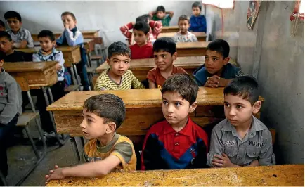  ?? PHOTO: REUTERS ?? Boys attend a war safety awareness campaign, given by Civil Defence members, inside a school in the rebel held besieged city of Douma, in the eastern Damascus suburb of Ghouta.