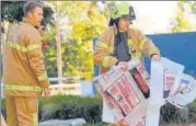  ??  ?? •A firefighte­r carries a hazardous material bag into the South Korean consulate in Melbourne on Wednesday.