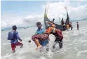  ??  ?? Human Tragedy: Braving perils to reach safe shore. Reuters