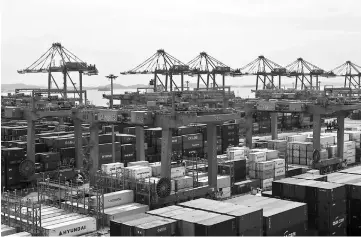  ??  ?? Containers sit stacked beneath gantry cranes at the Sun Kwang Newport Container Terminal (SNCT) in Incheon New Port in Incheon, South Korea, on Sept 4. — WP-Bloomberg photo