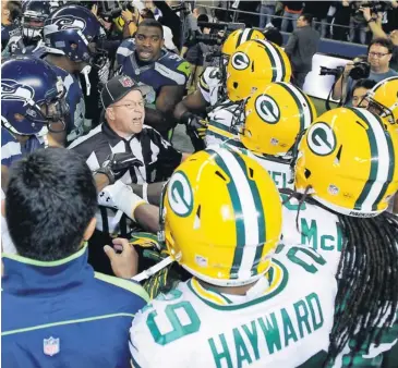  ?? STEVEN BISIG, US PRESSWIRE ?? Replacemen­t official Richard Simmons breaks up a fight between the Seahawks and Packers on Monday.
