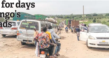  ?? — AFP photos ?? Public transport vehicles between Bukavu and Bujumbura in Burundi stuck on the road after the collapse of the bridge on national road number 5, in the village of Sange, South Kivu province, eastern Democratic Republic of Congo.