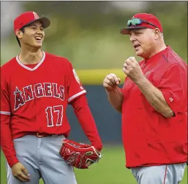  ?? BEN MARGOT / ASSOCIATED PRESS ?? The Angels’ multi-faceted Shohei Ohtani (left) smiles while listening to his manager, Mike Scioscia, during practice in Tempe, Ariz.