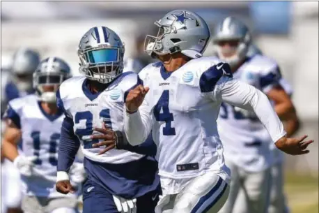  ?? GUS RUELAS — THE ASSOCIATED PRESS ?? Dallas Cowboys running back Ezekiel Elliott (21) and quarterbac­k Dak Prescott Cowboys training camp in Oxnard Wednesday. (4) run down the field during drills at