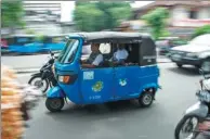  ?? BAY ISMOYO / AGENCE FRANCE-PRESSE ?? A three-wheeled bajaj taxi takes passengers to their destinatio­n in Jakarta, on Feb 13.