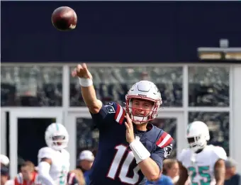  ?? Nancy LanE / HEraLd StaFF ?? MORE TO COME: Patriots rookie quarterbac­k Mac Jones warms up before facing the Dolphins on Sunday in Foxboro.