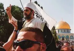  ??  ?? JEMAAH menjulang pengarah Masjid Al-Aqsa, Sheikh Omar Kiswani sambil bertakbir sebaik memasuki pekarangan Haram Al-Sharif, semalam. - AFP