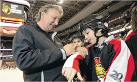  ??  ?? Senators owner Eugene Melnyk signs an autograph for Abdullah Alzouad during his annual Skate For Kids at Scotiabank Place Friday. Ninety students from two schools received Senators’ jerseys, new skates and helmets after watching the team practise.