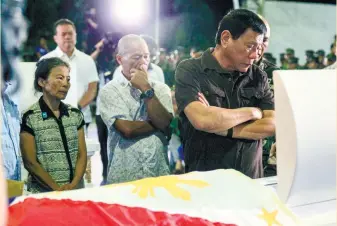  ?? (PNA FOTO) ?? PAYING RESPECTS. President Rodrigo R. Duterte views the remains of one of the four soldiers killed during a clash with the New People’s Army (NPA) rebels in Compostela Valley at the Naval Station Felix Apolinario in Panacan, Davao City on Aug. 7, 2016.