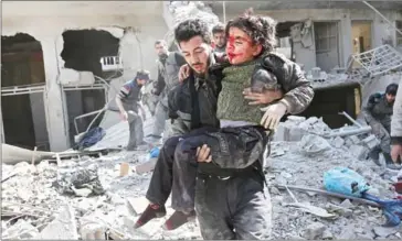  ?? ABDULMONAM EASSA/AFP ?? Syrians rescue a child following a reported regime airstrike in the rebel-held town of Hamouria, in the besieged Eastern Ghouta region on the outskirts of the capital Damascus yesterday.