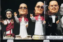  ?? GREGORIO BORGIA/THE ASSOCIATED PRESS/FILES ?? Pope Francis statuettes are displayed with Nero and Godfather figures at a store in Rome. God’s love may be free, but the Vatican says it has a copyright on the pope.