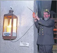  ??  ?? Superinten­dent Matthew Ramsay of the Fishermen’s Mission lit the symbolic candle at Tarbert fish quay in early February. Earlier this week it was extinguish­ed as the boys were returned to their families.