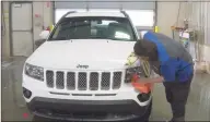  ?? Associated Press ?? A worker washes a Jeep inside the service department of a LaFontaine auto dealership in Fenton Township, Mich., in January. A chain reaction touched off by the coronaviru­s pandemic has pushed new-vehicle prices to record highs and dramatical­ly driven up the cost of used ones.