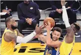  ?? JAE C. HONG/ASSOCIATED PRESS ?? Stephen Curry of the Warriors is surrounded by LeBron James, left, and Dennis Schroder of the Lakers on Monday night. Golden State rallied for a 115-113 victory.