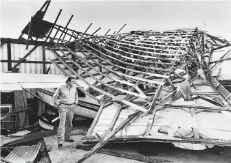  ?? Tribune News Service file photo ?? Pilot Charlie Morris of Panama City, Fla., inspects damage to a plane after Hurricane Kate in 1985. Experts are cautioning people not to get complacent about hurricane season’s end.