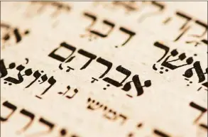  ?? Dreamstime ?? Closeup of Hebrew word Abraham on a Torah page.