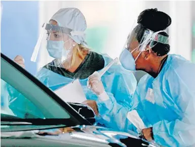  ?? MIKE STOCKER/SOUTH FLORIDA SUN SENTINEL ?? Health care workers prepare to collect samples at a testing site at the Miami-Dade County Auditorium in Miami. Florida continues to be one of the worst-hit states in the country.