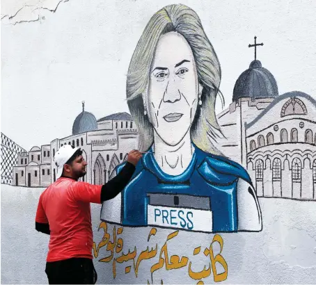  ?? AFP ?? A Palestinia­n artist paints a mural on Saturday honoring slain veteran Al-Jazeera journalist Shireen Abu Akleh in Khan Younis in the southern Gaza Strip.