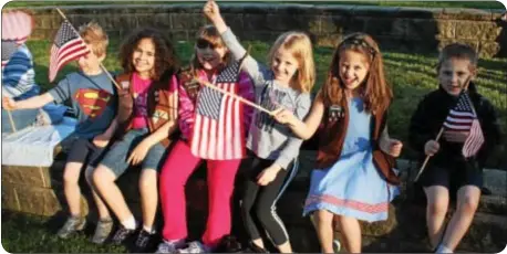  ??  ?? From left, Jimmy Donnelly, Michela Allen, Faith Elia, Kelly Donnelly, Emma Castellano and Luke Castellano wave new American flags as they wait for the ceremony featuring the proper disposal of tattered flags to begin.