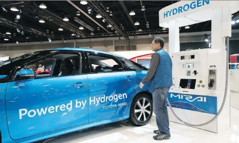  ?? RICHARD LAM ?? A visitor to the 2018 Vancouver Internatio­nal Auto Show looks over a Toyota Mirai.