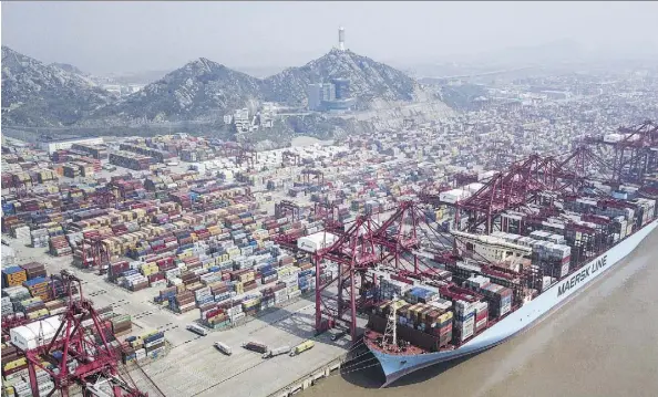  ?? QILAI SHEN/BLOOMBERG ?? Shipping containers stand in a terminal in Shanghai. Chinese President Xi Jinping announced on Tuesday a string of pledges, including raising the foreign ownership limit in the automobile, shipbuildi­ng and aircraft sectors “as soon as possible” and...
