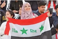  ?? Photo by M. Sajjad ?? An Iraqi fan is all smiles as she holds aloft her country’s flag during the match on Saturday. —