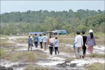  ?? ?? People walking in the Cardamom Mountains in Koh Kong province. Indigenous Cambodians are facing harassment, arrest and forced evictions from their traditiona­l territorie­s as a result of a carbon credit project, a Human Rights Watch report said.