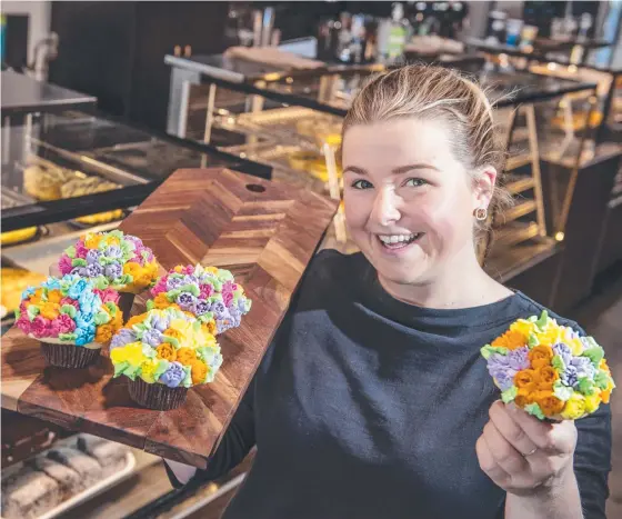  ?? Picture: Nev Madsen. ?? DELICIOUS: CC’s On The Range shop assistant Zara Warby with a selection of floral cupcakes.