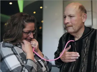  ?? MICHAEL BLACKSHIRE — CHICAGO TRIBUNE VIA AP ?? Amber Morgan, from South Bend, Ind., listens to the heartbeat of Tom Johnson, from Kankakee, at Travelodge by Wyndham Downtown Chicago on Saturday in Chicago. Morgan and Johnson met for the first time Saturday, four years after he received a heart transplant­ed from the body of Morgan’s daughter, Andreona Williams, who was 20when she died from asthma complicati­ons. “It’s almost like I got to hug my daughter again,” Morgan said.